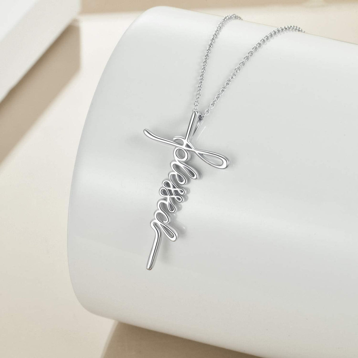 Silver necklace with a cross pendant on a wooden surface